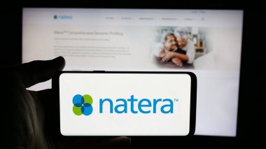 Stuttgart, Almanya - 12-06-2024: Üzerinde ABD 'li genetik test şirketi Natera Inc.' in logosu olan cep telefonu olan kişi iş sayfasının önünde ekranda. Telefon ekranına odaklan.