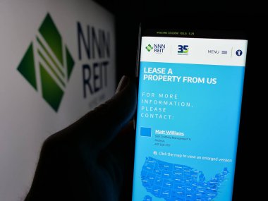 Stuttgart, Almanya - 12-09-2024: ABD 'li emlak şirketi NNN REIT Inc.' in web sayfası olan cep telefonu logonun önünde ekranda. Telefon ekranının merkezine odaklan.