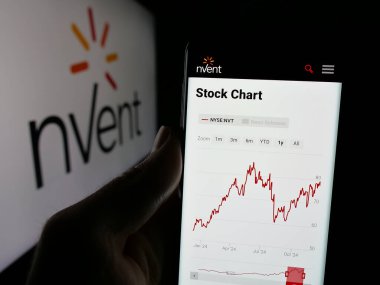 Stuttgart, Almanya - 12-09-2024: Logonun önündeki ekranda elektrik şirketi nVent Electric plc 'nin web sayfası bulunan akıllı telefon sahibi kişi. Telefon ekranının merkezine odaklan.