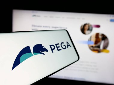 Stuttgart, Germany - 12-11-2024: Cellphone with logo of American software company Pegasystems Inc. (Pega) on screen in front of website. Focus on center-left of phone display. clipart