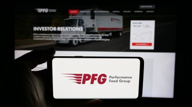 Stuttgart, Almanya - 12-11-2024: Amerikan Performance Food Group (PFG) şirketinin logosunun bulunduğu cep telefonu web sayfası önünde ekranda. Telefon ekranına odaklan.