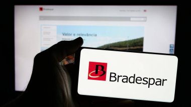 Stuttgart, Almanya - 12-13-2024: Brezilyalı holding şirketi Bradespar SA 'nın logosunun bulunduğu cep telefonu sahibi kişi iş sayfasının önünde ekranda. Telefon ekranına odaklan.