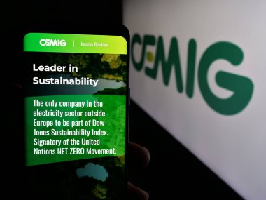 Stuttgart, Almanya - 12-16-2024: Companhia Energetica de Minas Gerais SA 'nın (CEMIG) web sayfası logolu cep telefonu tutan kişi. Telefon ekranının merkezine odaklan.