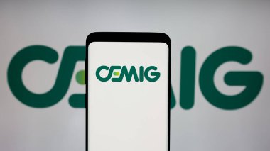 Stuttgart, Almanya - 12-16-2024: Ekranda Companhia Energetica de Minas Gerais SA (CEMIG) logosu bulunan cep telefonu. Telefon ekranına odaklan.