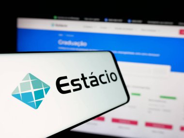 Stuttgart, Almanya - 12-16-2024: Brezilyalı eğitim şirketi Estacio SA 'nın logosunun yer aldığı akıllı telefon işletme web sitesinin önünde ekranda. Telefon ekranının merkez soluna odaklan.