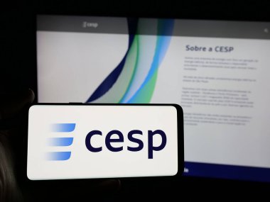 Stuttgart, Almanya - 12-16-2024: İnternet sitesi önünde Companhia Energetica de Sao Paulo SA (CESP) şirketinin logosuna sahip akıllı telefon sahibi kişi. Telefon ekranına odaklan.