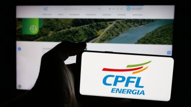 Stuttgart, Almanya - 12-16-2024: Brezilyalı enerji şirketi CPFL Energia SA 'nın logosunun bulunduğu cep telefonu sahibi kişi iş sayfasının önünde ekranda görülüyor. Telefon ekranına odaklan.