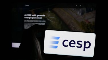 Stuttgart, Almanya - 12-16-2024: İnternet sayfası önünde üzerinde Companhia Energetica de Sao Paulo SA (CESP) logosu bulunan cep telefonu sahibi kişi. Telefon ekranına odaklan.