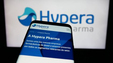 Stuttgart, Almanya - 12-18-2024: Brezilyalı ilaç şirketi Hypera SA 'nın web sitesi ile cep telefonu iş logosu önünde ekranda. Telefon ekranının sol üst kısmına odaklan.