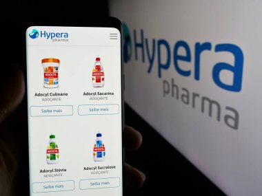 Stuttgart, Almanya - 12-18-2024: Brezilyalı ilaç şirketi Hypera SA 'nın web sayfası ile cep telefonu sahibi kişi iş logosu önünde ekranda. Telefon ekranının merkezine odaklan.