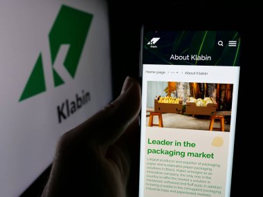 Stuttgart, Almanya - 12-18-2024: Brezilyalı kağıt şirketi Klabin SA 'nın web sayfası ile cep telefonu sahibi kişi iş logosu önünde ekranda. Telefon ekranının merkezine odaklan.