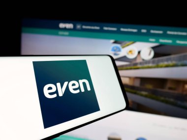 Stuttgart, Almanya - 12-18-2024: Web sitesinin önünde ekranda Even Construtora e Incorporadora SA şirketinin logosu bulunan cep telefonu. Telefon ekranının merkez soluna odaklan.