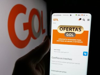 Stuttgart, Almanya - 12-18-2024: Brezilyalı şirket Gol Linhas Aarea Inteligentes SA 'nın web sayfası ile cep telefonu tutan kişi logo ile ekranda. Telefon ekranının merkezine odaklan.