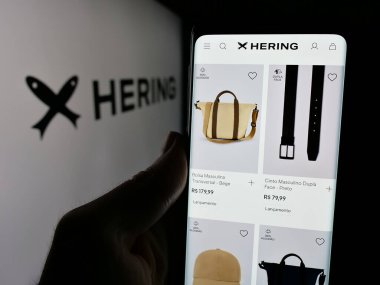 Stuttgart, Almanya - 12-18-2024: Brezilyalı moda şirketi Hering 'in internet sayfası olan cep telefonu logosu önünde ekranda. Telefon ekranının merkezine odaklan.