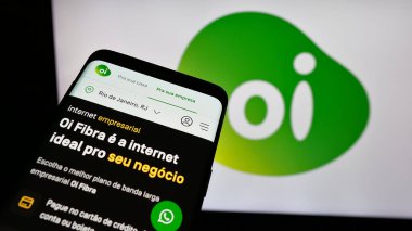 Stuttgart, Almanya - 12-19-2024: Brezilyalı telekomünikasyon şirketi Oi SA 'nın web sitesi ile birlikte iş logosu önünde cep telefonu. Telefon ekranının sol üst kısmına odaklan.