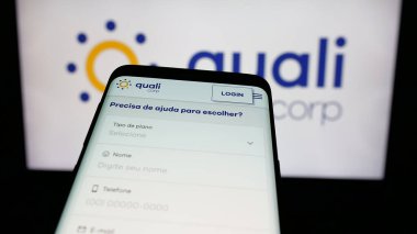 Stuttgart, Almanya - 12-19-2024: Brezilyalı sağlık sigorta şirketi Qualicorp SA 'nın web sitesiyle birlikte logo önünde cep telefonu. Telefon ekranının sol üst kısmına odaklan.