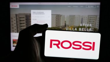 Stuttgart, Almanya - 12-19-2024: Brezilyalı emlak şirketi Rossi Residencial SA 'nın logosunun bulunduğu cep telefonu web sayfası önünde ekranda. Telefon ekranına odaklan.