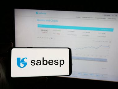 Stuttgart, Almanya - 12-19-2024: Brezilyalı atık yönetim şirketi Sabesp SA 'nın logosunu elinde tutan kişi web sitesinin önünde ekranda. Telefon ekranına odaklan.
