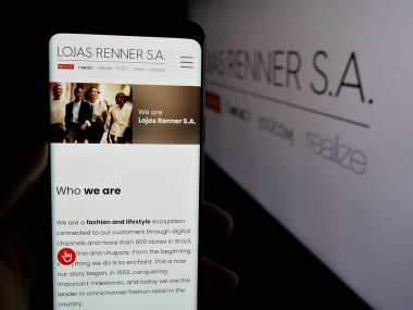 Stuttgart, Almanya - 12-19-2024: Brezilyalı giyim şirketi Lojas Renner SA 'nın web sitesi ile akıllı telefon taşıyan kişi logonun önünde ekranda. Telefon ekranının merkezine odaklan.