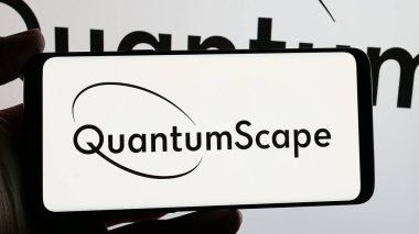 Stuttgart, Germany - 12-20-2024: Person holding smartphone with logo of US battery company QuantumScape Corporation on screen. Focus on phone display. clipart