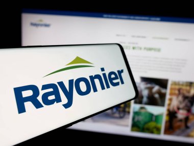 Stuttgart, Almanya - 12-27-2024: Amerikan kereste REIT şirketi Rayonier Inc. 'in logosu olan cep telefonu iş sitesinin önünde ekranda. Telefon ekranının merkez soluna odaklan.