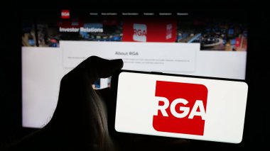 Stuttgart, Almanya - 12-27-2024: Web sayfası önünde ekranda Amerikan Resurance Group of America Inc. (RGA) logosunun bulunduğu cep telefonu sahibi kişi. Telefon ekranına odaklan.