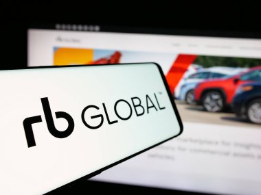 Stuttgart, Almanya - 12-27-2024: RB Global Inc. 'in logosuna sahip cep telefonu. (Ritchie Bros. açık arttırmacılar) iş dünyasının web sitesinin önünde ekranda. Telefon ekranının soluna odaklan.