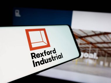 Stuttgart, Almanya - 12-30-2024: Web sitesinin önünde ekranda ABD 'li emlak şirketi Rexford Industrial Realty Inc.' in logosunun bulunduğu cep telefonu. Telefon ekranının merkez soluna odaklan.