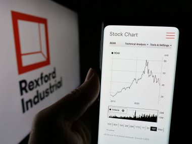 Stuttgart, Almanya - 12-30-2024: ABD 'li emlak şirketi Rexford Industrial Realty Inc.' in web sayfası ile cep telefonu sahibi kişi logo ile ekranda. Telefon ekranının merkezine odaklan.