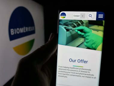 Stuttgart, Almanya - 01-02-2024: Fransız biyoteknoloji şirketi biyoMerieux SA 'nın web sayfası olan cep telefonu logosu önünde ekranda. Telefon ekranının merkezine odaklan.