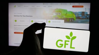 Stuttgart, Almanya - 01-02-2024: Kanadalı GFL Environmental Inc. şirketinin logosunun bulunduğu cep telefonu sahibi kişi iş sayfasının önünde ekranda. Telefon ekranına odaklan.