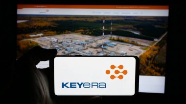 Stuttgart, Almanya - 01-02-2024: Kanadalı petrol şirketi Keyera Corporation 'ın logosuyla cep telefonu sahibi kişi iş sayfasının önünde ekranda. Telefon ekranına odaklan.
