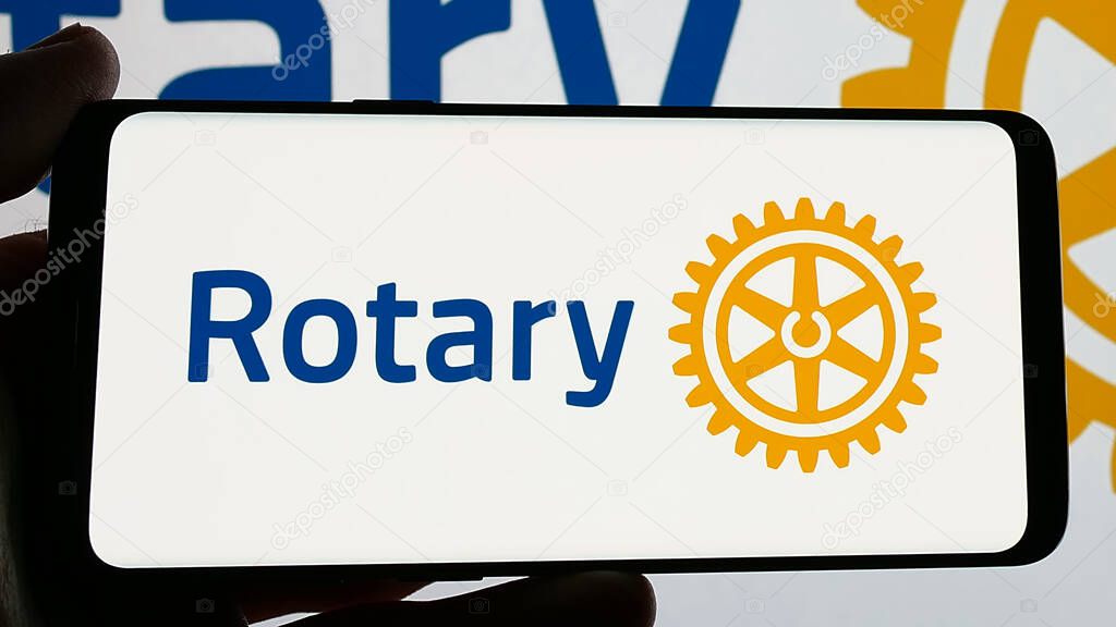 Stuttgart, Germany - 12-30-2024: Person holding smartphone with logo of service club Rotary International on screen. Focus on phone display.