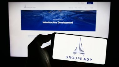 Stuttgart, Almanya - 07-17-2023: Fransız havaalanı operatörü Groupe ADP 'nin logosunun bulunduğu cep telefonu sahibi kişi iş sayfasının önünde ekranda. Telefon ekranına odaklan.