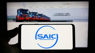 Stuttgart, Almanya - 07-17-2023: Çinli otomotiv şirketi SAIC Motor Corp. Lt. nin logosu olan cep telefonu web sayfasının önünde ekranda. Telefon ekranına odaklan.