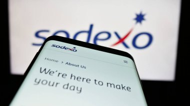 Stuttgart, Almanya - 07-17-2023: Fransız tesis yönetimi şirketi Sodexo S.A. 'nın web sitesiyle birlikte cep telefonu logonun önünde ekranda. Telefon ekranının sol üst kısmına odaklan.