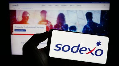 Stuttgart, Almanya - 07-17-2023: Fransız tesis yönetimi şirketi Sodexo S.A. 'nın logosunun bulunduğu cep telefonu web sayfası önünde ekranda. Telefon ekranına odaklan.