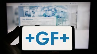 Stuttgart, Almanya - 07-18-2023: İsviçreli firma Georg Fischer AG 'nin (GF) logosunu elinde tutan kişi web sitesi önünde ekranda. Telefon ekranına odaklan.