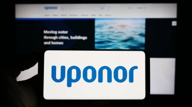 Stuttgart, Almanya - 07-18-2023: Fin su teknolojisi şirketi Uponor Oyj 'un logosunun bulunduğu cep telefonu sahibi kişi iş sayfasının önünde ekranda görülüyor. Telefon ekranına odaklan.