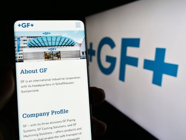 Stuttgart, Almanya - 07-18-2023: İsviçreli firma Georg Fischer AG 'nin (GF) internet sayfası logo önünde bulunan kişi. Telefon ekranının merkezine odaklan.