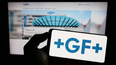 Stuttgart, Almanya - 07-18-2023: İsviçreli firma Georg Fischer AG 'nin (GF) logosuyla cep telefonu sahibi kişi iş sayfası önünde ekranda. Telefon ekranına odaklan.