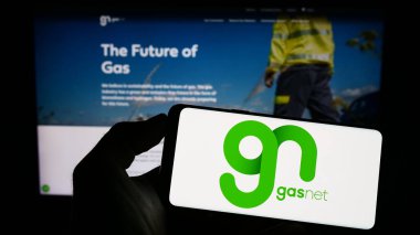 Stuttgart, Almanya - 07-18-2023: Çek doğalgaz dağıtım şirketi GasNet sro 'nun logosuyla cep telefonu sahibi kişi iş sayfasının önünde ekranda. Telefon ekranına odaklan.