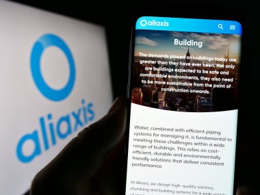 Stuttgart, Almanya - 07-18-2023: Belçikalı plastik şirketi Aliaxis SA 'nın web sayfası olan cep telefonu logosu önünde ekranda. Telefon ekranının merkezine odaklan.