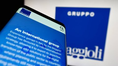 Stuttgart, Almanya - 07-18-2023: Bilgi teknolojileri şirketi Maggioli SpA 'nın web sitesi olan akıllı telefon iş logosu önünde ekranda. Telefon ekranının sol üst kısmına odaklan.