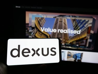 Stuttgart, Almanya - 06-18-2023: Avustralyalı emlak şirketi Dexus Group 'un logosunu elinde tutan kişi web sitesinin önünde ekranda. Telefon ekranına odaklan.