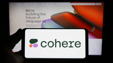 Stuttgart, Almanya - 06-18-2023: Kanadalı AI şirketi Cohere Inc. 'in logosunu elinde tutan kişi web sitesinin önünde ekranda. Telefon ekranına odaklan.