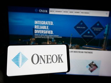 Stuttgart, Almanya - 06-18-2023: ABD 'li doğalgaz şirketi Oneok Inc.' in logosuyla akıllı telefon sahibi kişi web sitesinin önünde ekranda. Telefon ekranına odaklan.