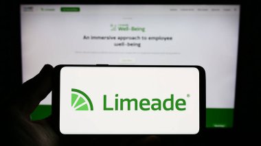 Stuttgart, Almanya - 06-18-2023: Web sitesi önünde ekranda ABD 'li çalışan refah şirketi Limeade Inc.' in logosuna sahip akıllı telefon sahibi kişi. Telefon ekranına odaklan.