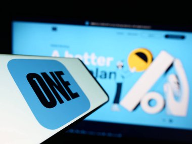 Stuttgart, Almanya - 06-18-2023: ABD 'li fintech şirketi One Finance Inc.' in logosuna sahip cep telefonu. (One App) iş dünyasının web sitesinin önünde ekranda. Telefon ekranının soluna odaklan.