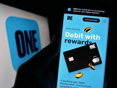 Stuttgart, Almanya - 06-18-2023: ABD 'li fintech şirketi One Finance Inc. (One App)' in web sitesi ile akıllı telefon sahibi kişi ekranda logolu. Telefon ekranının merkezine odaklan.